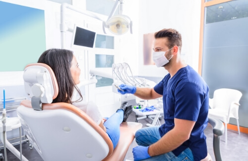 Dentist smiling at a patient in the dental chair
