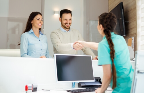 Man shaking hands with dental office receptionist