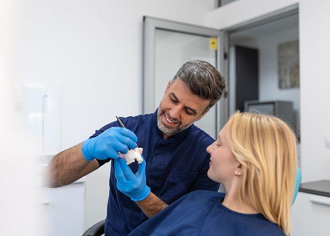 A dentist showing a plaster mold to his patient