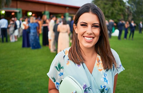 Wedding guest smiling while standing outside