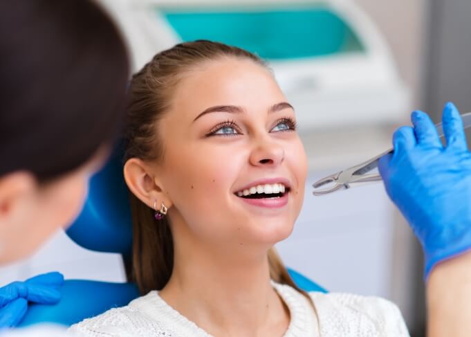 Woman smiling in dental chair before tooth extractions in Grantsville