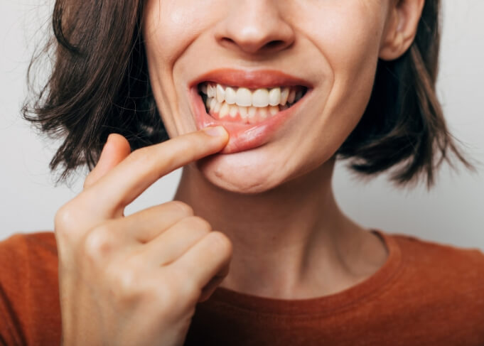 Woman pointing to red spot in her gums before gum disease treatment in Grantsville