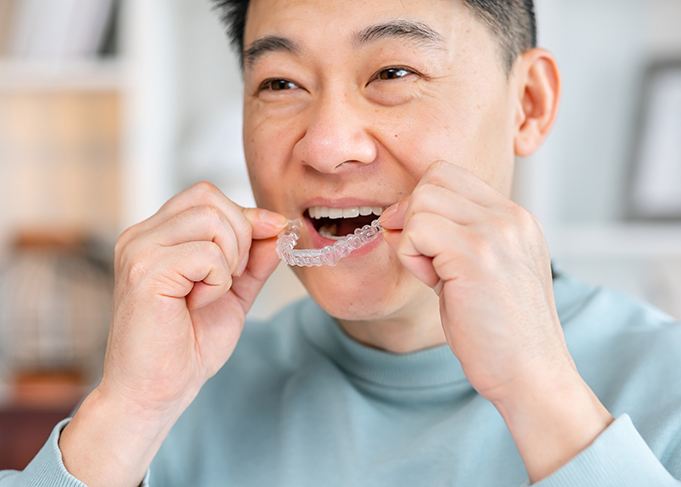 Patient in Grantsville putting their Invisalign aligners in