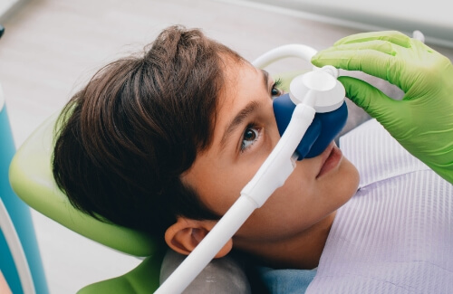 Young boy in dental chair wearing nitrous oxide nose mask