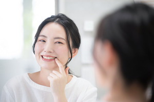 Women checking teeth in the mirror